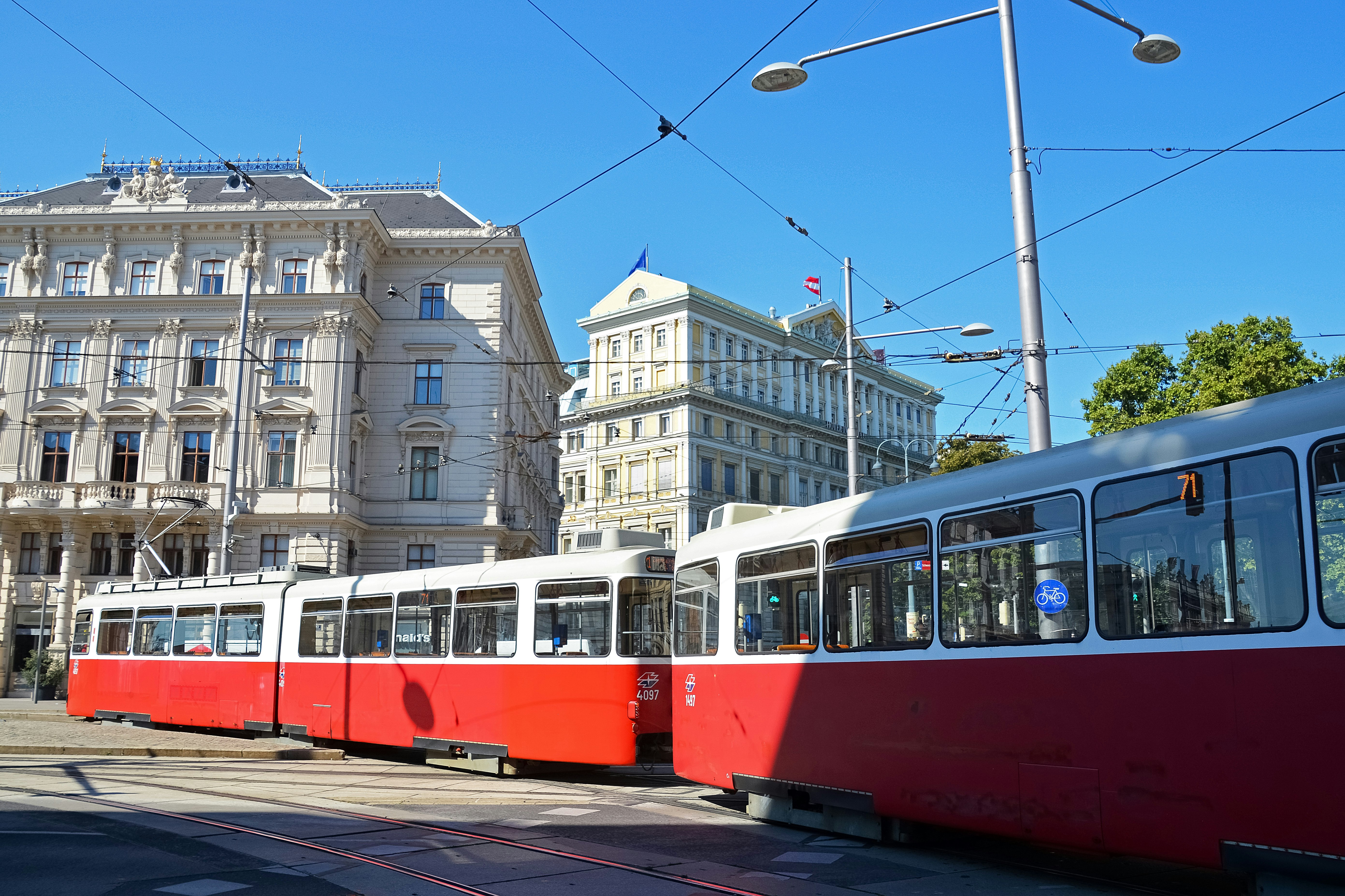 red and white tram on road near white concrete building during daytime